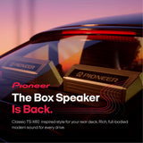 Pioneer rear deck box speaker shown installed on a car window, with promotional text reading 'The Box Speaker Is Back.' and a sunset-colored background.