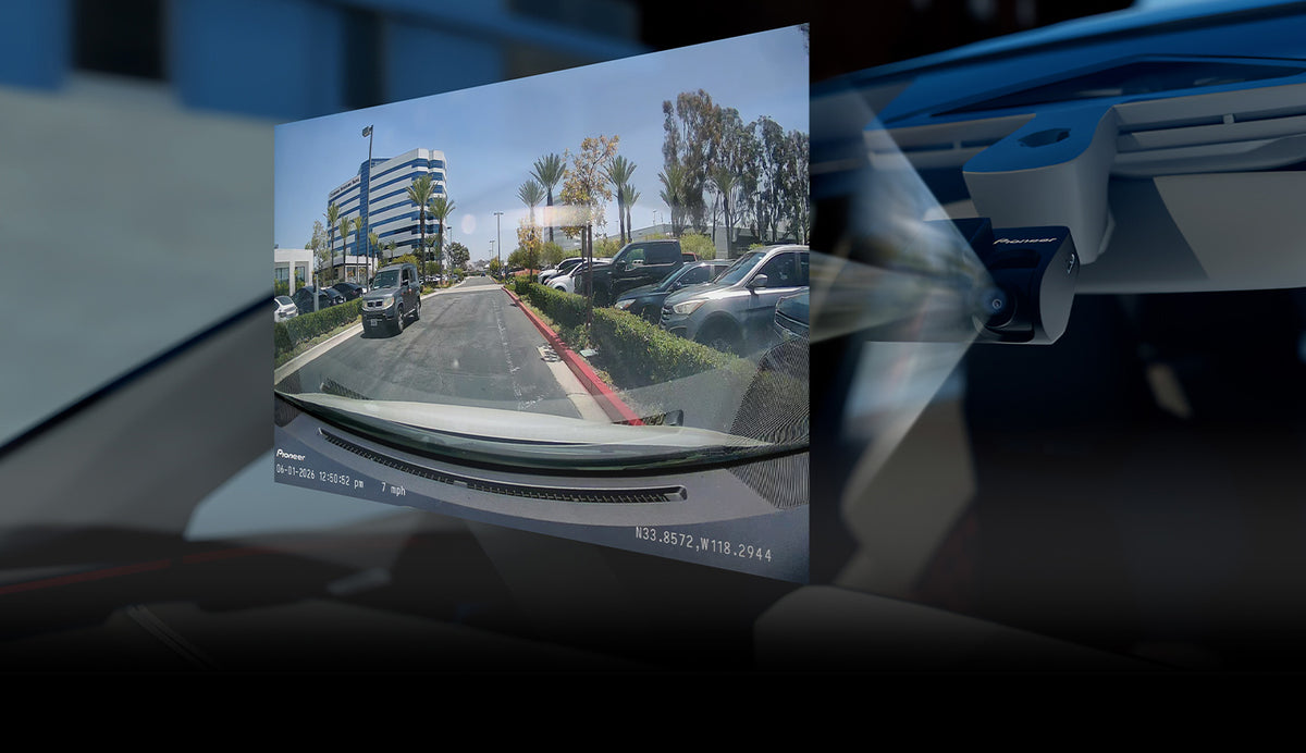 A close-up of a car's windshield and dashboard showing a rearview mirror or glass replacement application overlay, with a blurred outdoor street scene visible in the reflection.